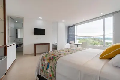a bedroom with a large bed and a large window at Hotel Santorini in Guatapé