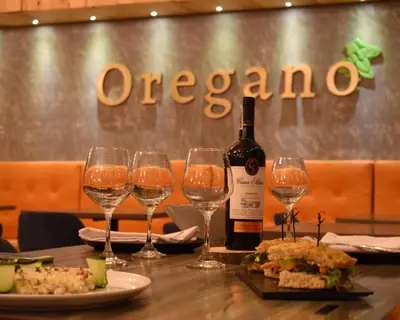 a table with a bottle of wine and wine glasses at Hotel Santorini in Guatapé