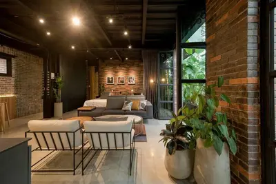 a living room with chairs and a brick wall at Meridiano Apartments in Medellín