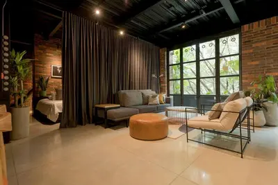 a living room with a couch and a chair and a table at Meridiano Apartments in Medellín