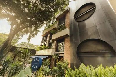 a building with a large door and a tree at Meridiano Apartments in Medellín