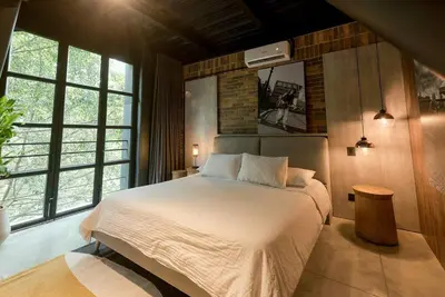 a bedroom with a large bed in a room with windows at Meridiano Apartments in Medellín