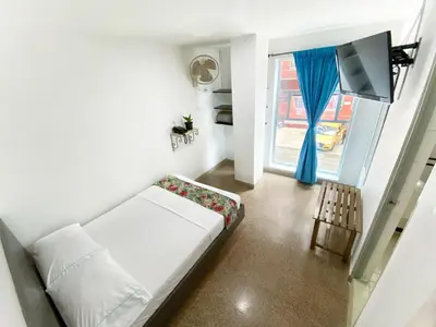 a living room with a white couch and a window at Hotel Plaza Mayor Itagui in Itagüí