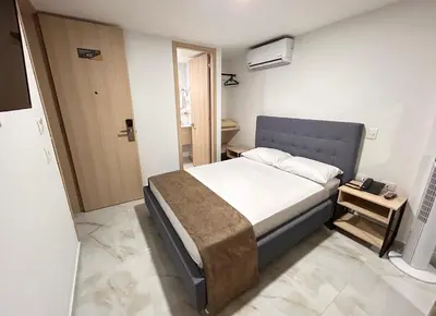 a bedroom with a bed in a room at Hotel Plaza Mayor Itagui in Itagüí
