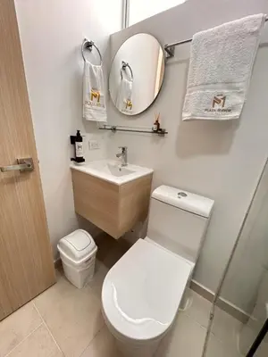 a bathroom with a toilet and a sink and a mirror at Hotel Plaza Mayor Itagui in Itagüí