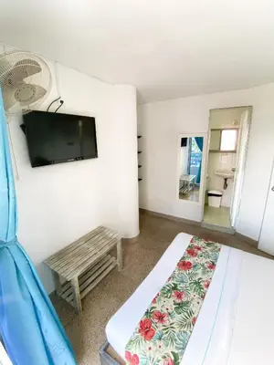 a room with a bed and a tv and a bench at Hotel Plaza Mayor Itagui in Itagüí