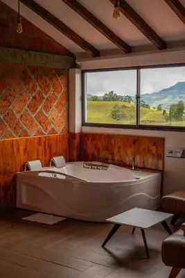 a large tub in a room with a large window at Hotel Santa Laura in Jericó