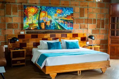 a bedroom with a bed with a painting on the wall at Hotel Santa Laura in Jericó