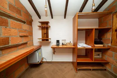a room with a brick wall and wooden shelves at Hotel Santa Laura in Jericó