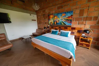 a bedroom with a large bed and a brick wall at Hotel Santa Laura in Jericó
