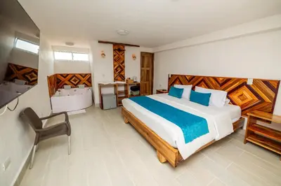 a bedroom with a large bed and a sink at Hotel Santa Laura in Jericó