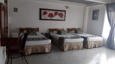 a room with two beds in a room at Hotel Mirador Santana in Anserma