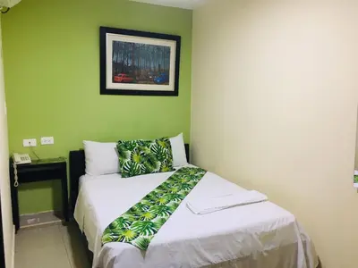 a bedroom with a bed with a green wall at Hotel Ecosuite Quibdó in Quibdó