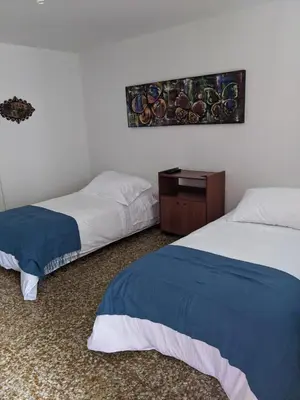 a bedroom with two beds and a painting on the wall at Hacienda Guayabal in Chinchiná
