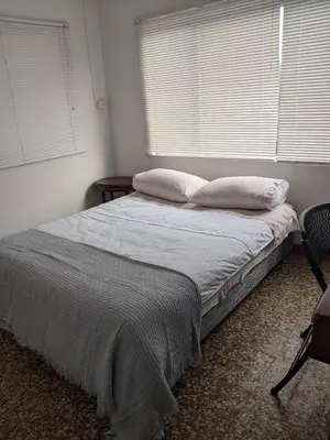 a bedroom with a bed with two pillows and a window at Hacienda Guayabal in Chinchiná