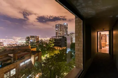 a view of a city at night from a building at Lettera Hotel in Medellín