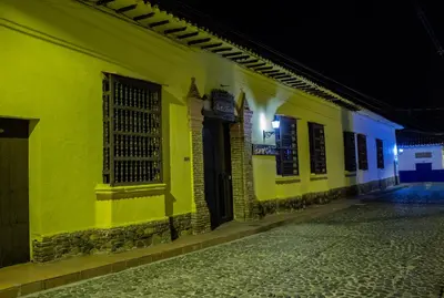 an empty street at night with a yellow building at Casa Hotel Guaracú in Santa Fe de Antioquia