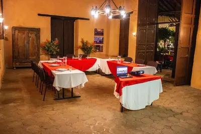 a group of tables with red and white table cloth at Casa Hotel Guaracú in Santa Fe de Antioquia
