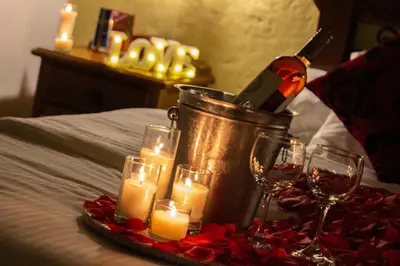 a bottle of wine in a bucket with candles and roses at Casa Hotel Guaracú in Santa Fe de Antioquia