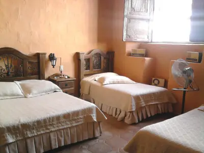 a bedroom with two beds and a fan at Casa Hotel Guaracú in Santa Fe de Antioquia