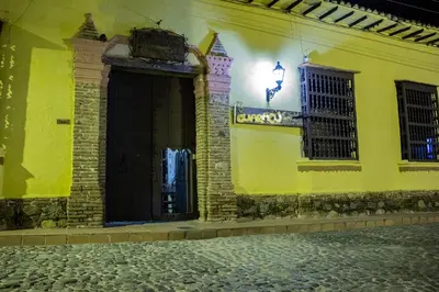 a yellow building with two windows and a street at Casa Hotel Guaracú in Santa Fe de Antioquia
