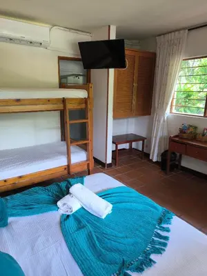a bedroom with two bunk beds and a flat screen tv at Hosteria Guaracú in San Jerónimo
