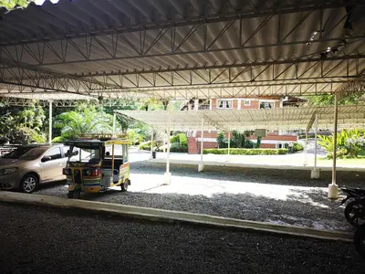 a small vehicle parked in a parking lot with a car at Hosteria Guaracú in San Jerónimo