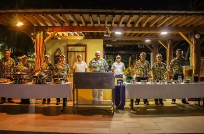 a group of people in hawaiian shirts standing behind tables at Hosteria Guaracú in San Jerónimo