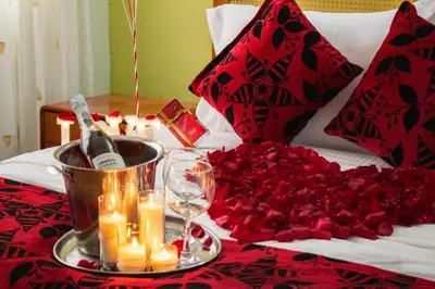 a table with candles and roses on a bed at Hosteria Guaracú in San Jerónimo