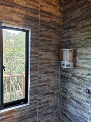 a bathroom with a window and a tiled wall at La Zenerchi in Rionegro