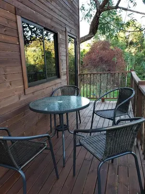 a patio with four chairs and a table on a deck at La Zenerchi in Rionegro