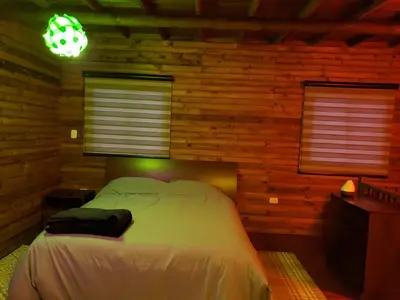 a bedroom with a bed in a log cabin at La Zenerchi in Rionegro