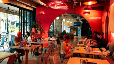 a group of people sitting at tables in a restaurant at Viajero Medellín Hostel in Medellín