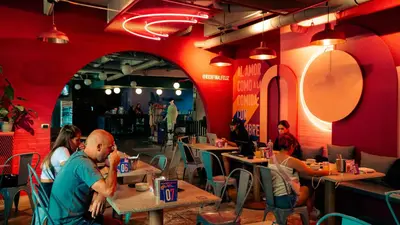 a group of people sitting at tables in a restaurant at Viajero Medellín Hostel in Medellín