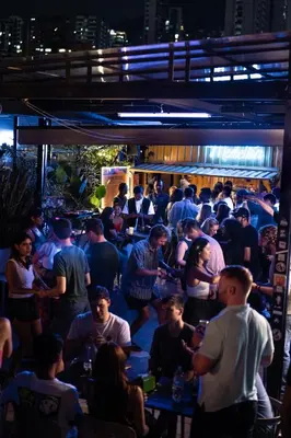 a crowd of people in a bar at night at Viajero Medellín Hostel in Medellín