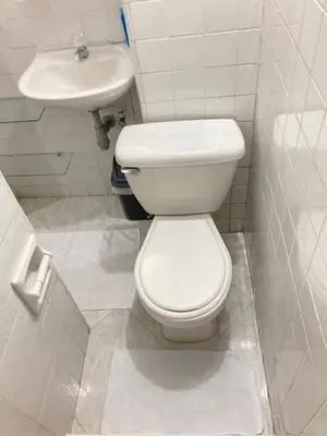 a white bathroom with a toilet and a sink at Roomies House By Rincon in Medellín