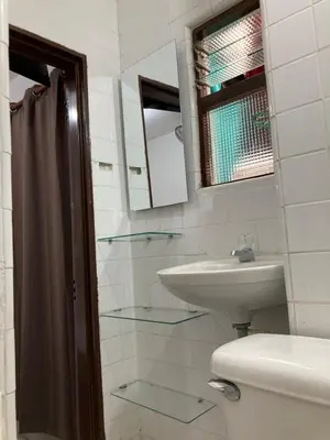 a bathroom with a sink and a toilet and a mirror at Roomies House By Rincon in Medellín