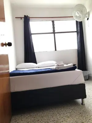 a bed in a room with a window and a bed sidx sidx sidx at Roomies House By Rincon in Medellín