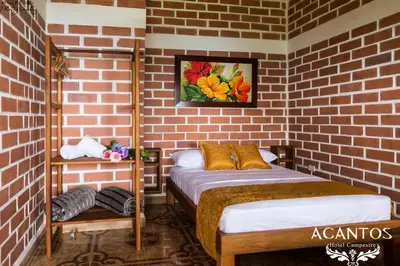 a room with two beds and a brick wall at Acantos Hotel Campestre in Támesis