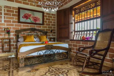 a bedroom with a bed and a chair and a window at Acantos Hotel Campestre in Támesis