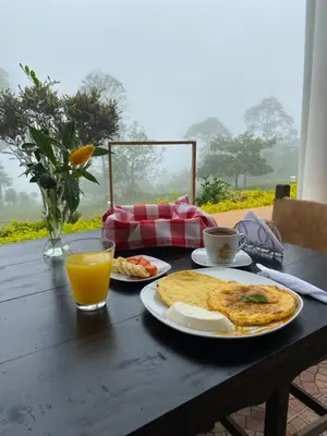 a table with two plates of food and a glass of orange juice at Acantos Hotel Campestre in Támesis