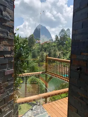 an open door to a balcony with a view of the mountains at Sotavento Cabañas in Guatapé