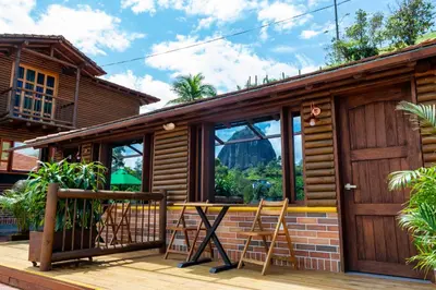 a cabin with a table and chairs on a deck at Sotavento Cabañas in Guatapé
