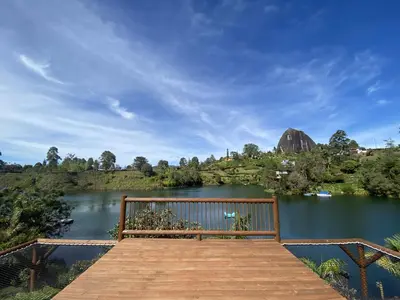a wooden dock with a bench on a lake at Sotavento Cabañas in Guatapé