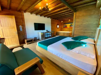 a bedroom with a large bed and a television at Sotavento Cabañas in Guatapé