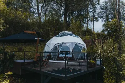 a yurt on a table with chairs and an umbrella at Domus Glamping Guatapé in Guatapé