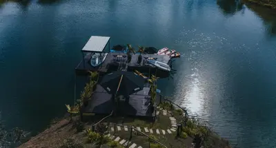 an overhead view of a dock with an umbrella in the water at Domus Glamping Guatapé in Guatapé