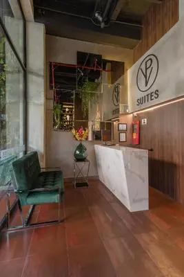 a lobby with a green chair and a counter at VPV Suites in Medellín
