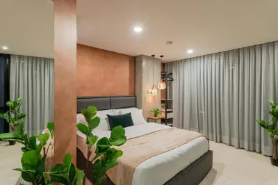 a bedroom with a large bed and some plants at VPV Suites in Medellín