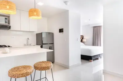 a kitchen with a counter and two stools at Origen Local Suites in Medellín